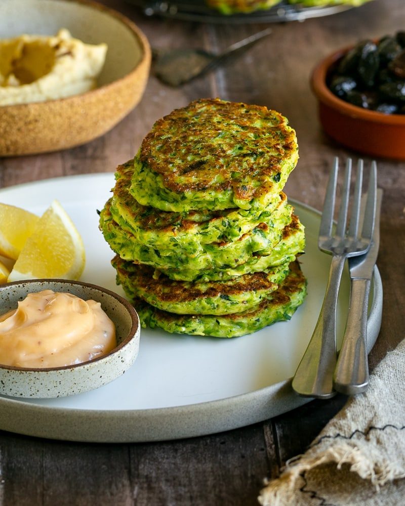 Stack of fritters in a plate with condiments on the side