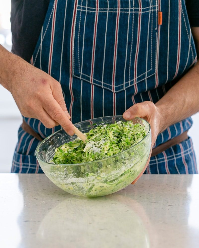 mixing a bowl with a zucchini batter