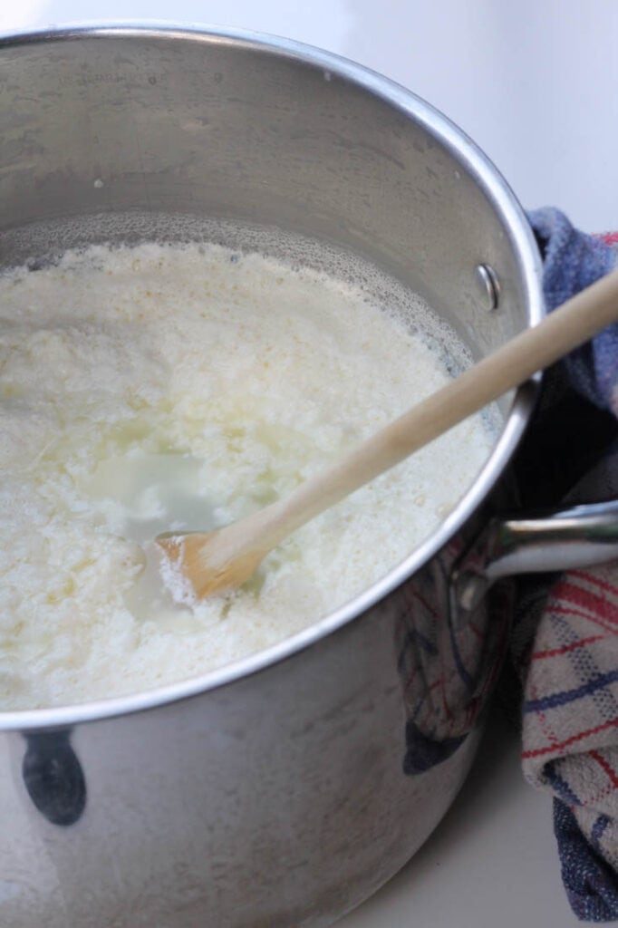 pot with curdled cheese for making ricotta