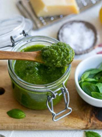 Basil Pesto in a jar with a wooden spoon