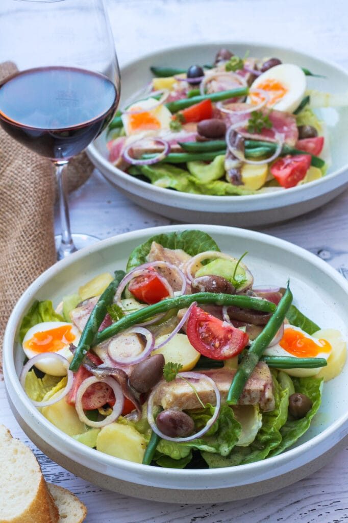bowl with tuna salad and glass of wine
