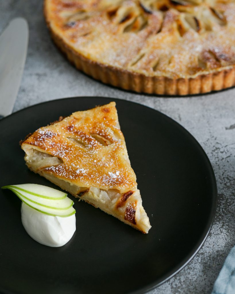Slice of the apple tart with garnish on the side