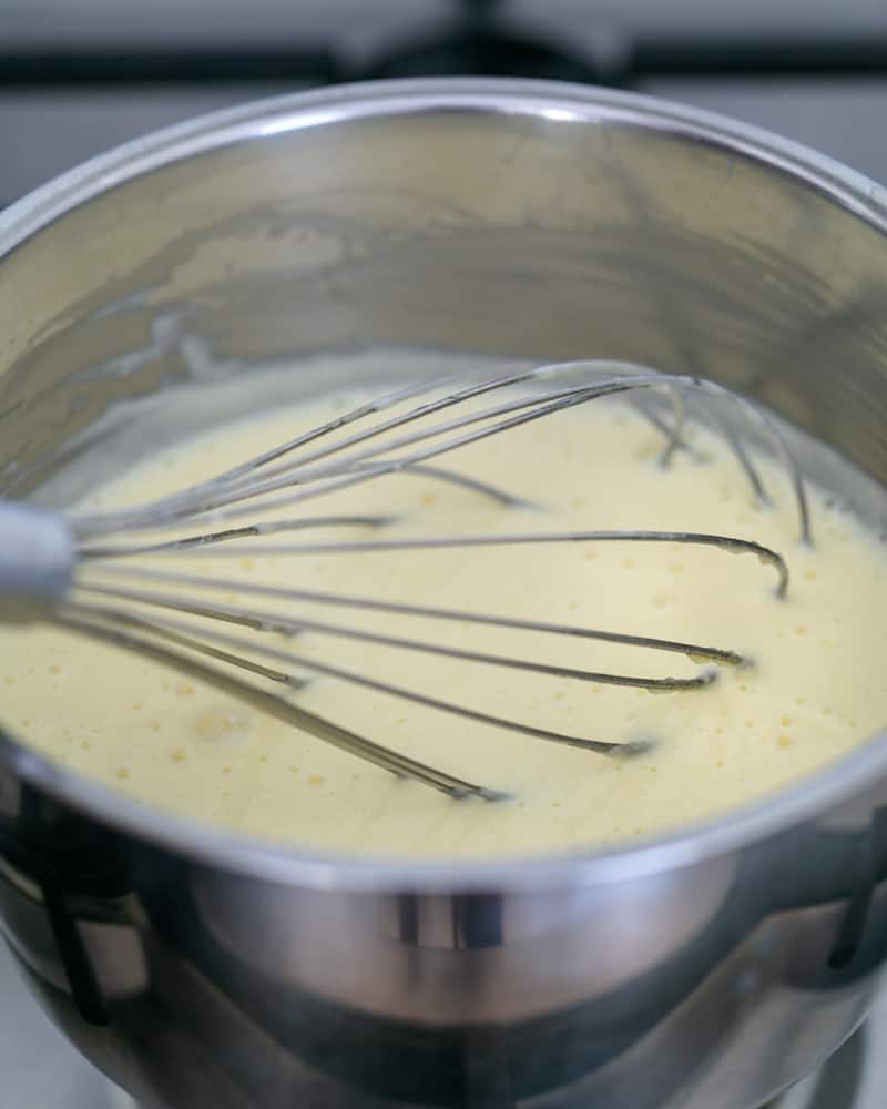 Creme fraiche, coconut milk in a pot with a whisk in it