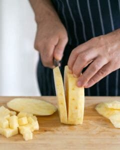 Chopping and dicing peeled pineapple