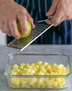 Grating lime zest on cooked pineapple dices