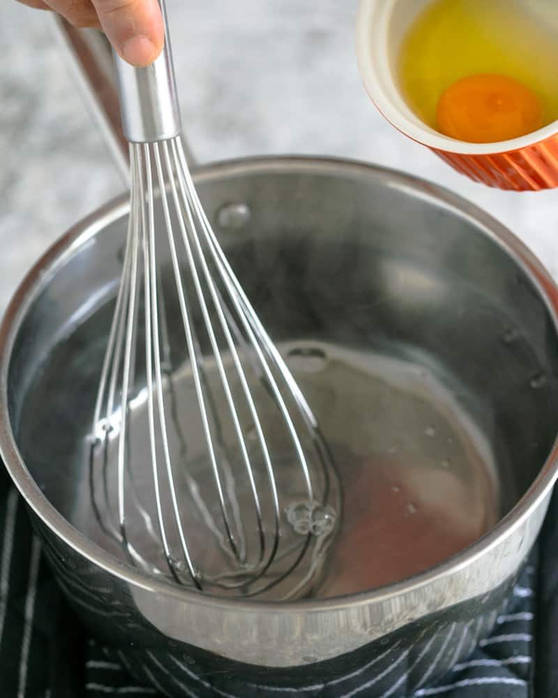 Swirling method, pot of hot water, whisk and egg in a ramekin