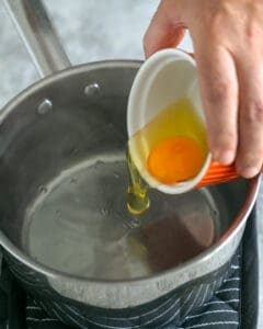 Adding egg to swirling hot water in a pan