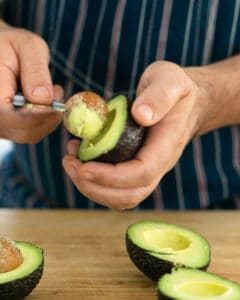 Removing the stone from half cut avocado