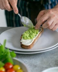 Avocado mix spread over a slice of toasted sourdough