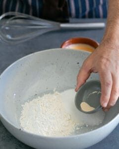 Adding dry yeast to bowl of flour and sugar