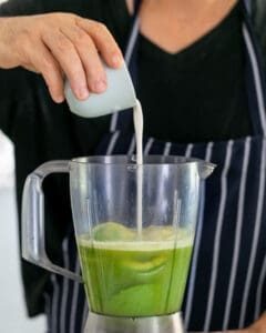 Coconut cream added to apple lime juice and avocado in the mixer