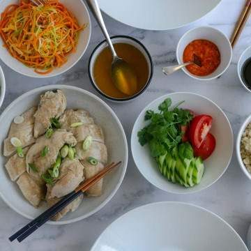 Overhead shot of the whole chicken, ginger rice, Chilli sauce and all other condiments