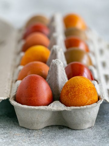 colored easter eggs in an egg carton