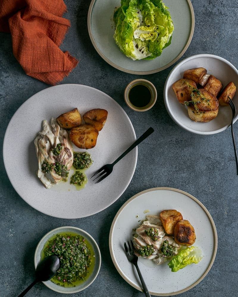 fish plated up with salsa verde and sides