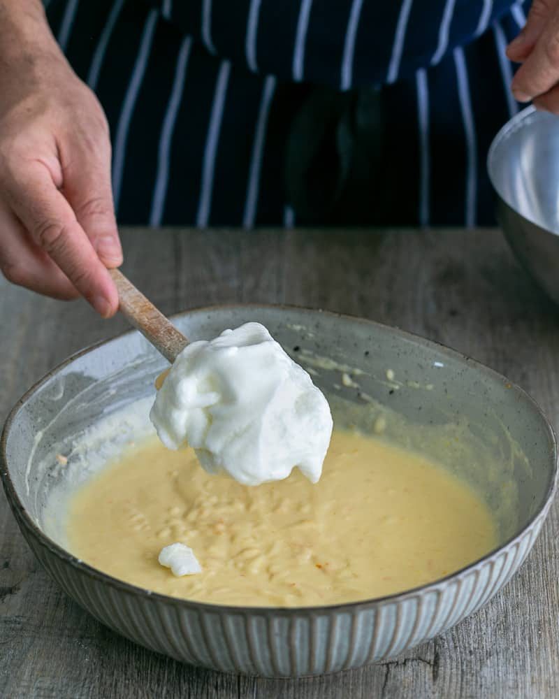 Folding in Whipped Egg Whites into Pancake Batter for Souffle-style pancakes with fresh ricotta and almonds