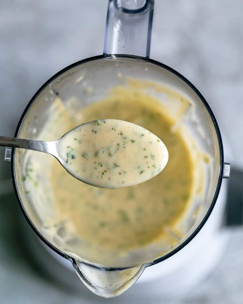 With a spoon showing the final consistency of the garlic aioli