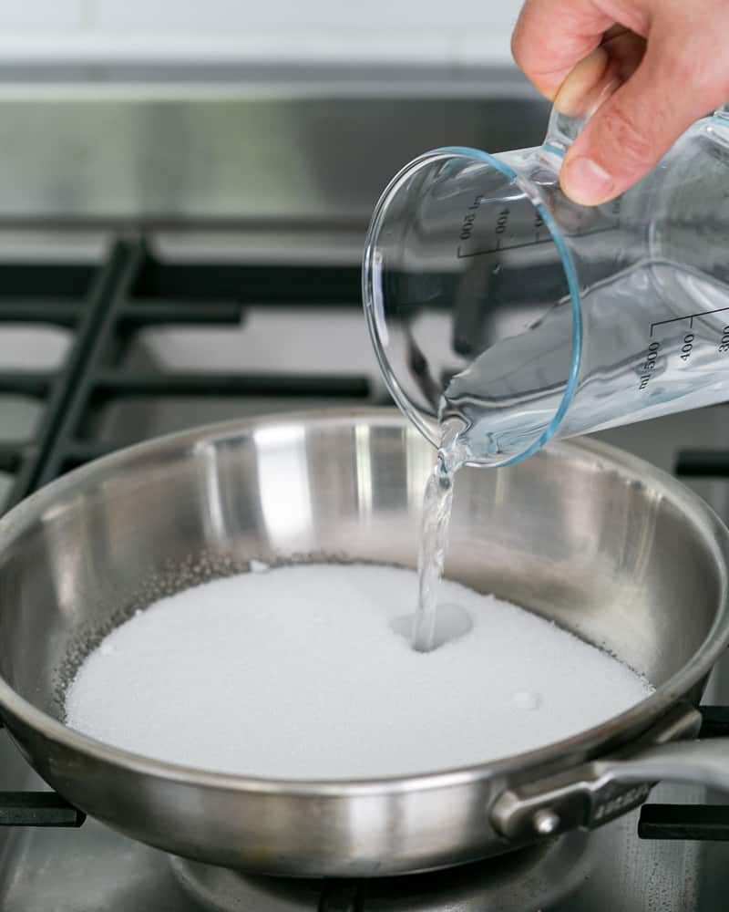 Adding water to the sugar in the hot pan