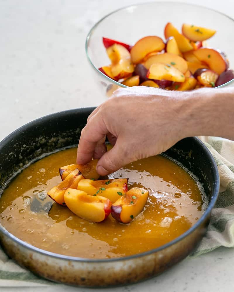 Place the plum wedges skin side down in the prepared caramel in the pan