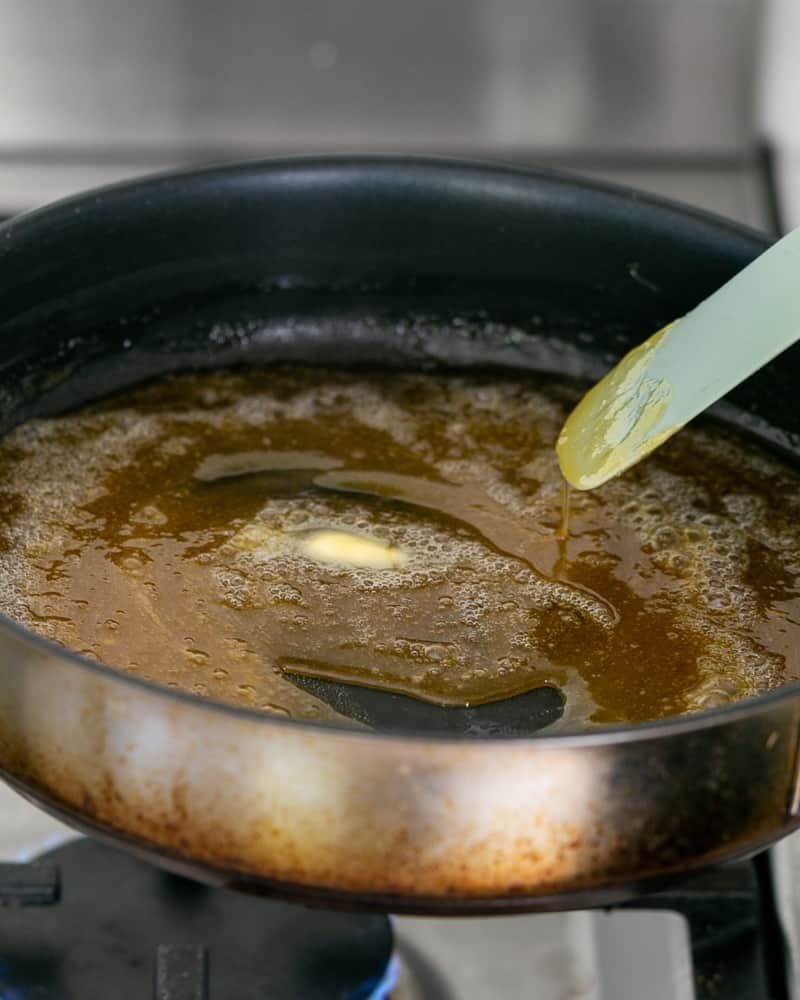 Add unsalted butter cubes one by one to the caramel