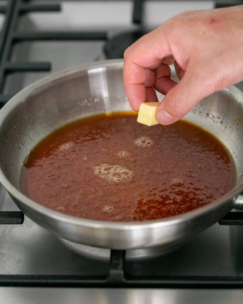 Adding butter cubes to the caramel one by one