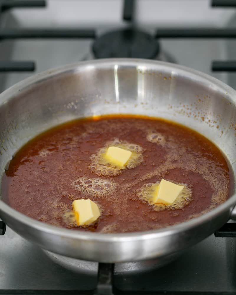 Adding butter cubes to the caramel one by one