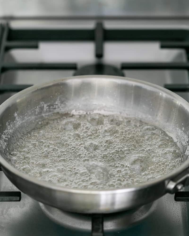 Sugar dissolving in water before turning to caramel