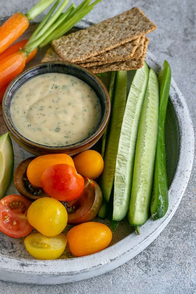 Variety of crudities in a white plate with a small bowl of Garlic aioli