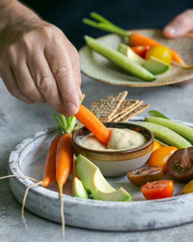 Dipping a baby carrot in the garlic aioli sauce