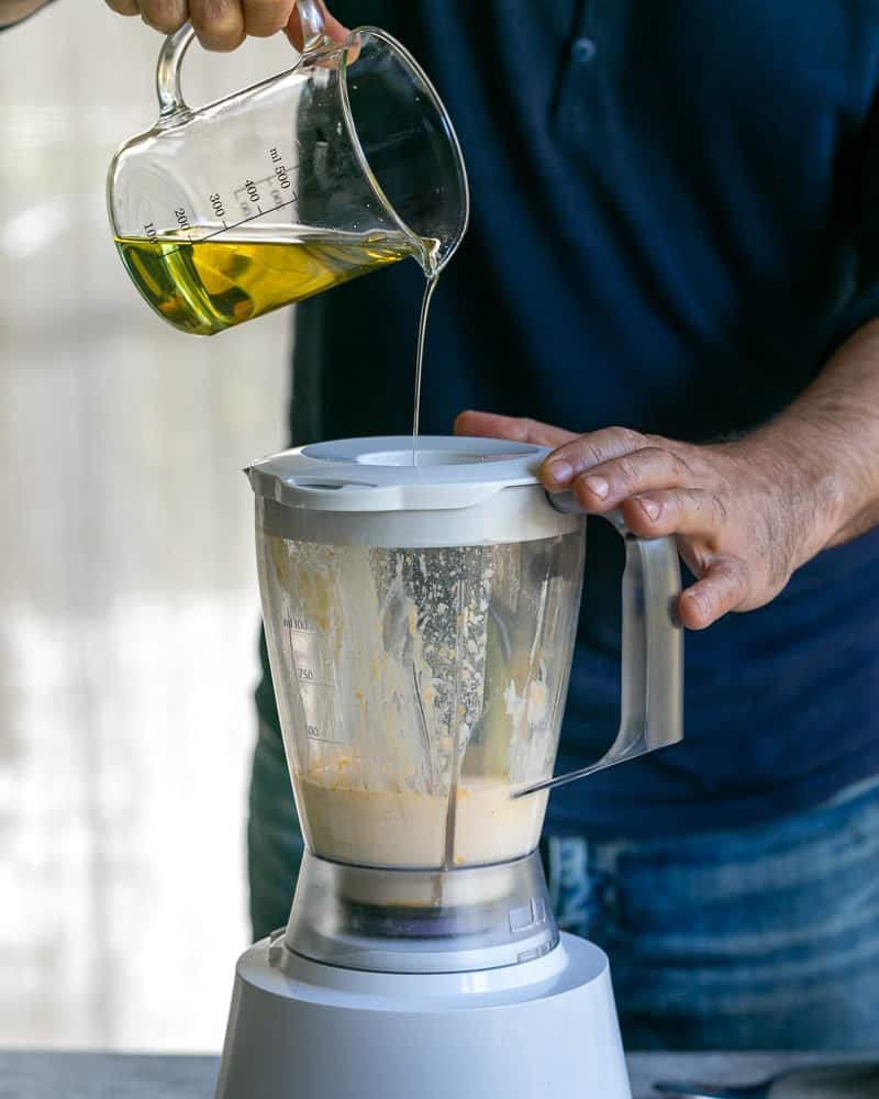 Adding grape seed oil slowly to the mixture in the blender