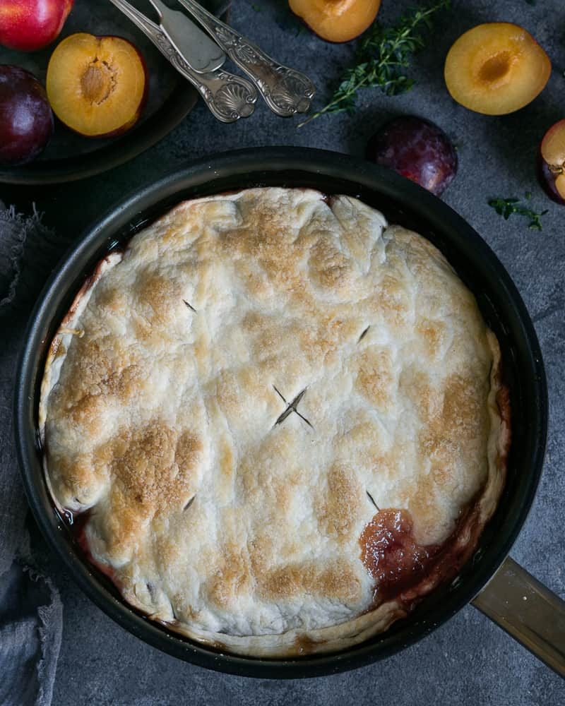 Freshly cooked plum tarte tatin out of the oven in a pan