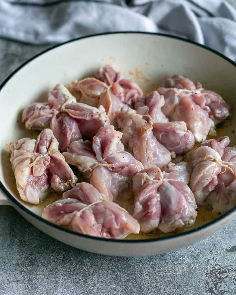 Searing the tied chicken thighs skin down in a hot pan