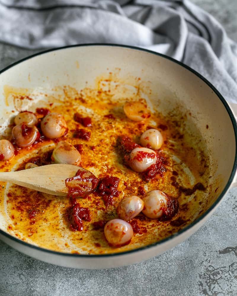 Roasting tomato paste with seared shallots in the pan