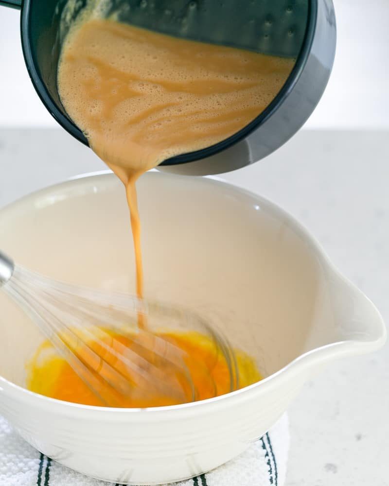 Pour the Caramel and milk and cream mixture over the whisked eggs in the bowl