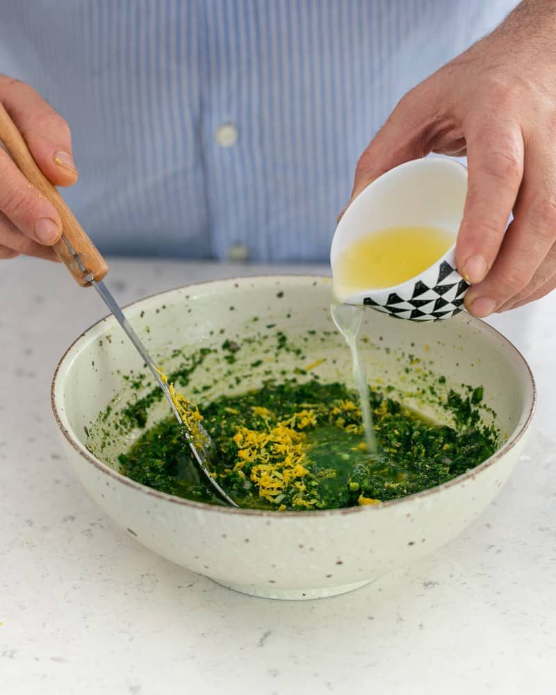 Adding lemon juice to chimichurri with lemon zest
