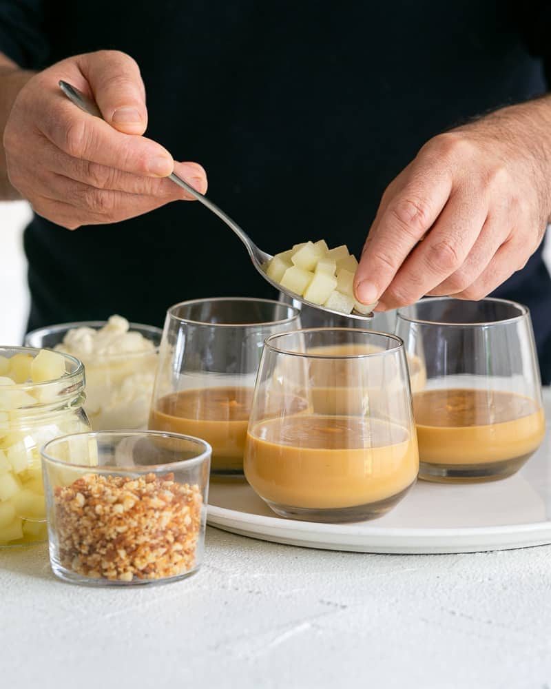 Placing poached diced pears on the set caramel petit pots