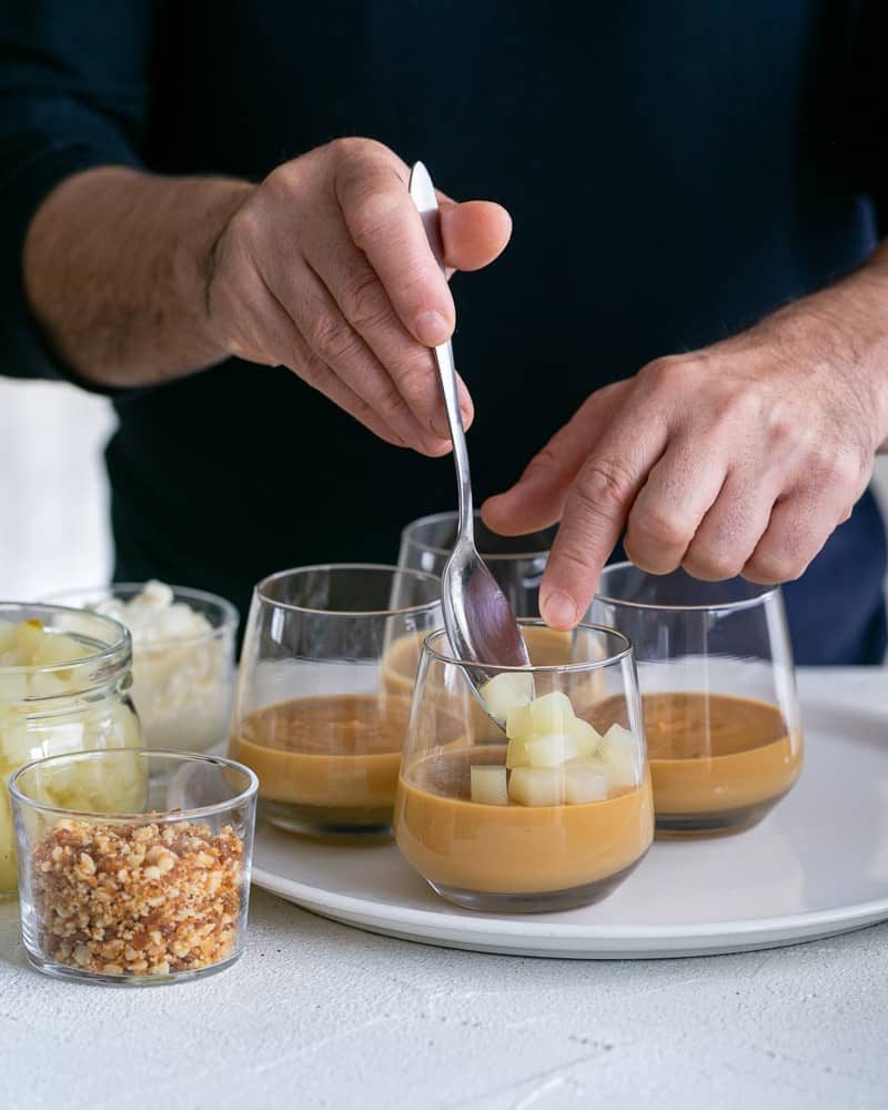 Layering the caramel petit pots with poached diced pears