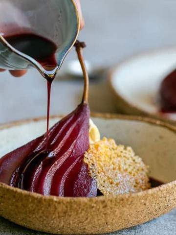 Spiced poached pears with mascarpone in a bowl with Wine syrup poured over