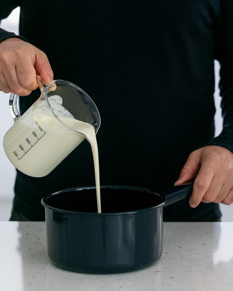 Milk and sugar in a pan with vanilla and salt to make creme caramel