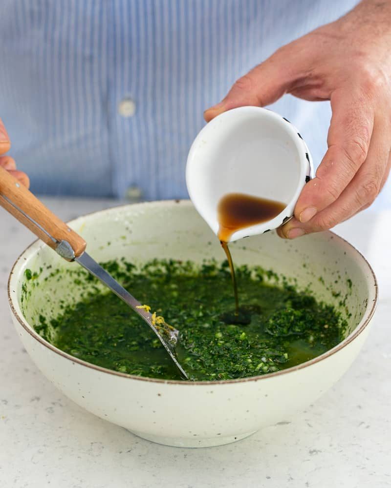 Adding red wine vinegar to the prepared chimichurri sauce