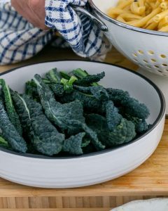 Cut kale in a white bowl for Casarecce Pasta with Asparagus, Kale and Garlic