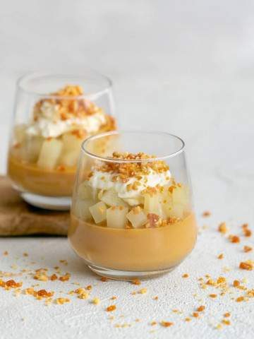caramel pots with poached pears, whipped cream and macadamia crumble in a glass