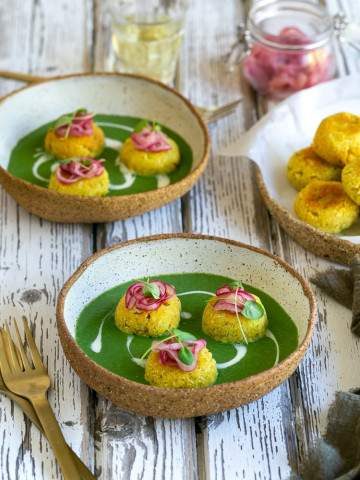 Paneer and Potato Dumplings with Spinach Sauce served in a ceramic bowl