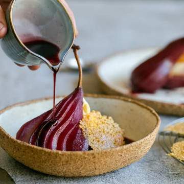 Spiced poached pears with mascarpone in a bowl with Wine syrup poured over