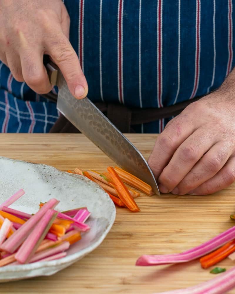 A person chopping stems of the swiss chard to make Baked sweet Potato with Lentils and Swiss Chard