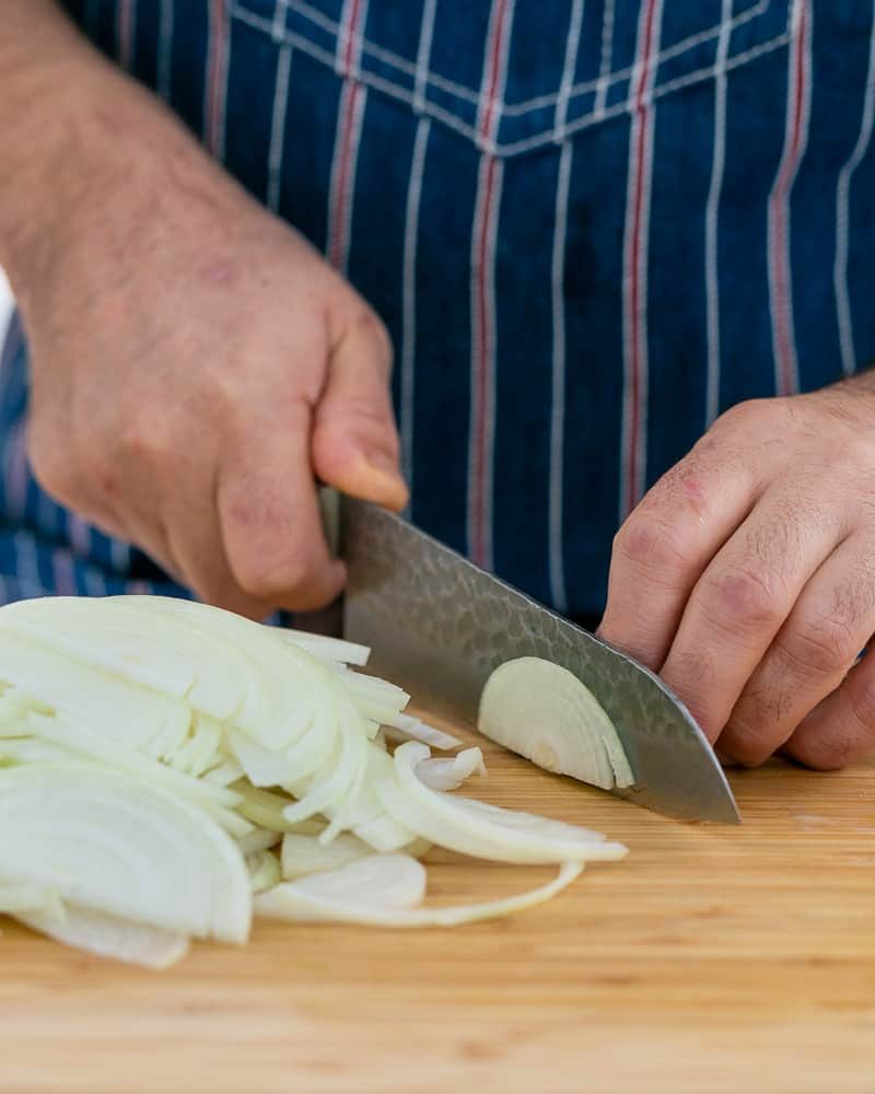 Slicing brown onion to make topping for Chopped garlic added to brown lentils in pan to make Baked sweet Potato with Lentils and Swiss Chard