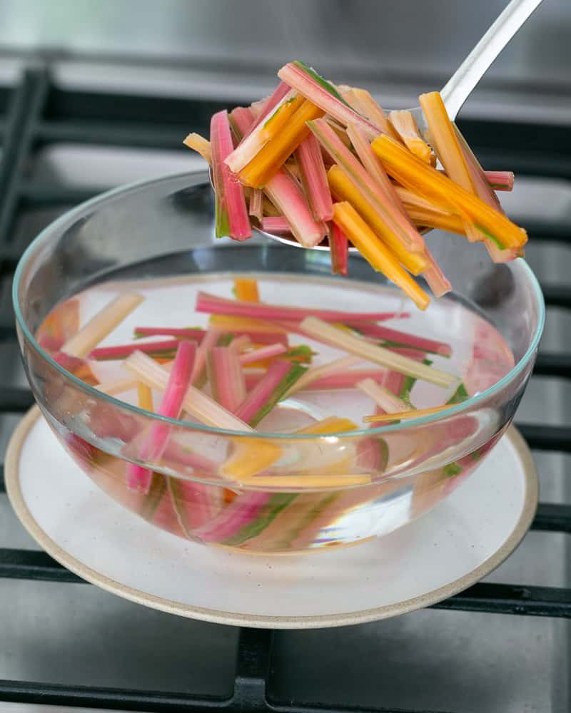 Refreshing the blanched swiss chard stems in cold water