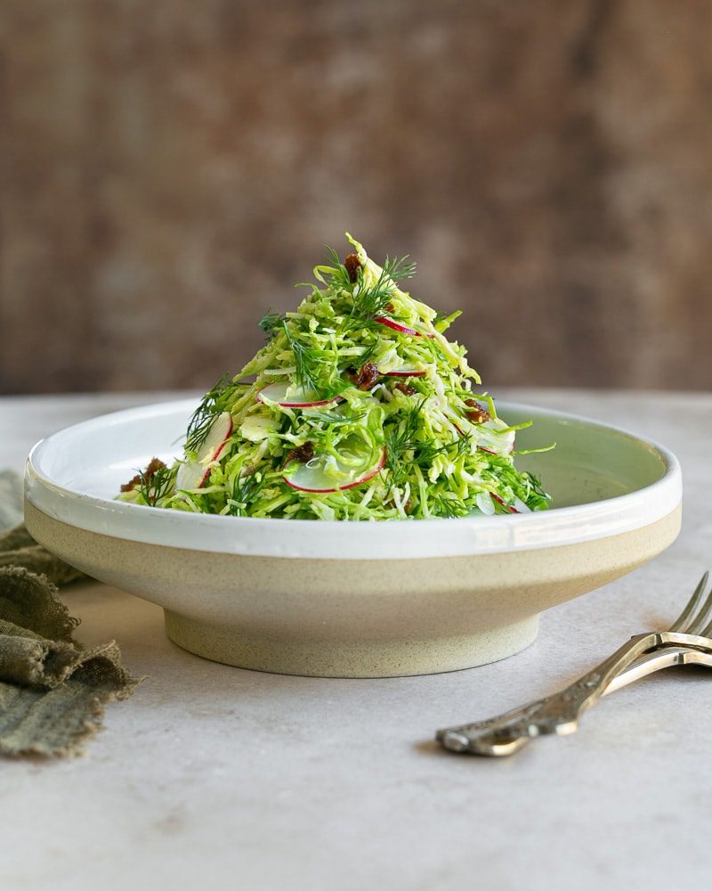 Brussels sprout slaw with raisins in a bowl