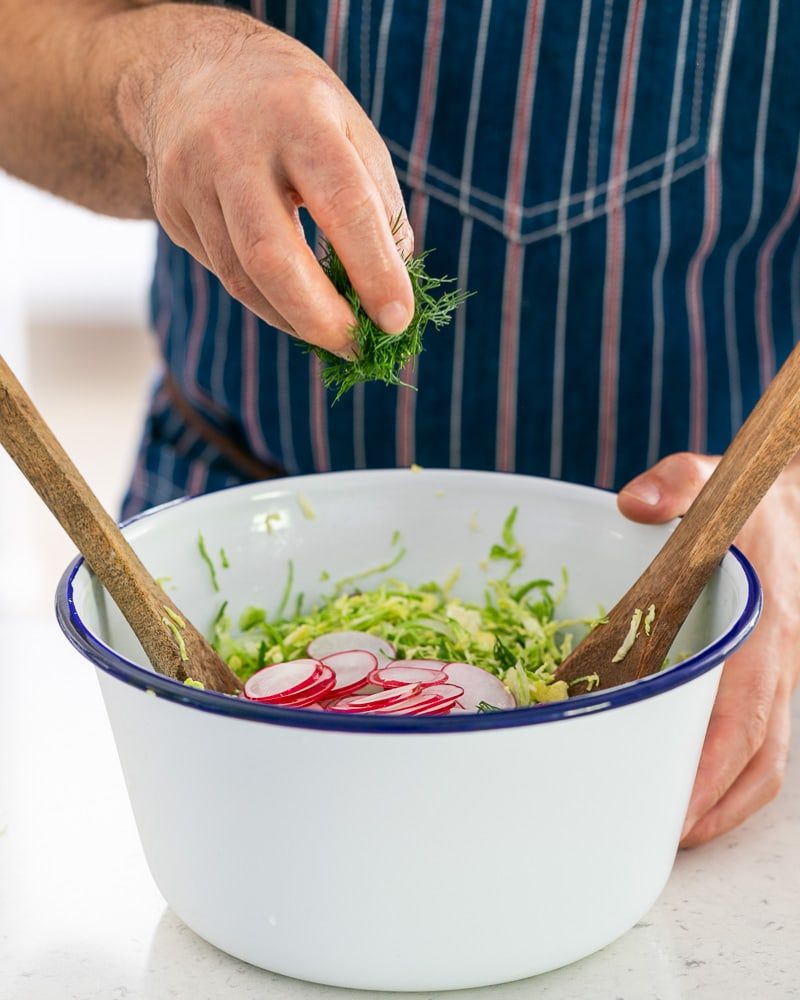 Sliced radish and chopped dill added to the brussels sprouts