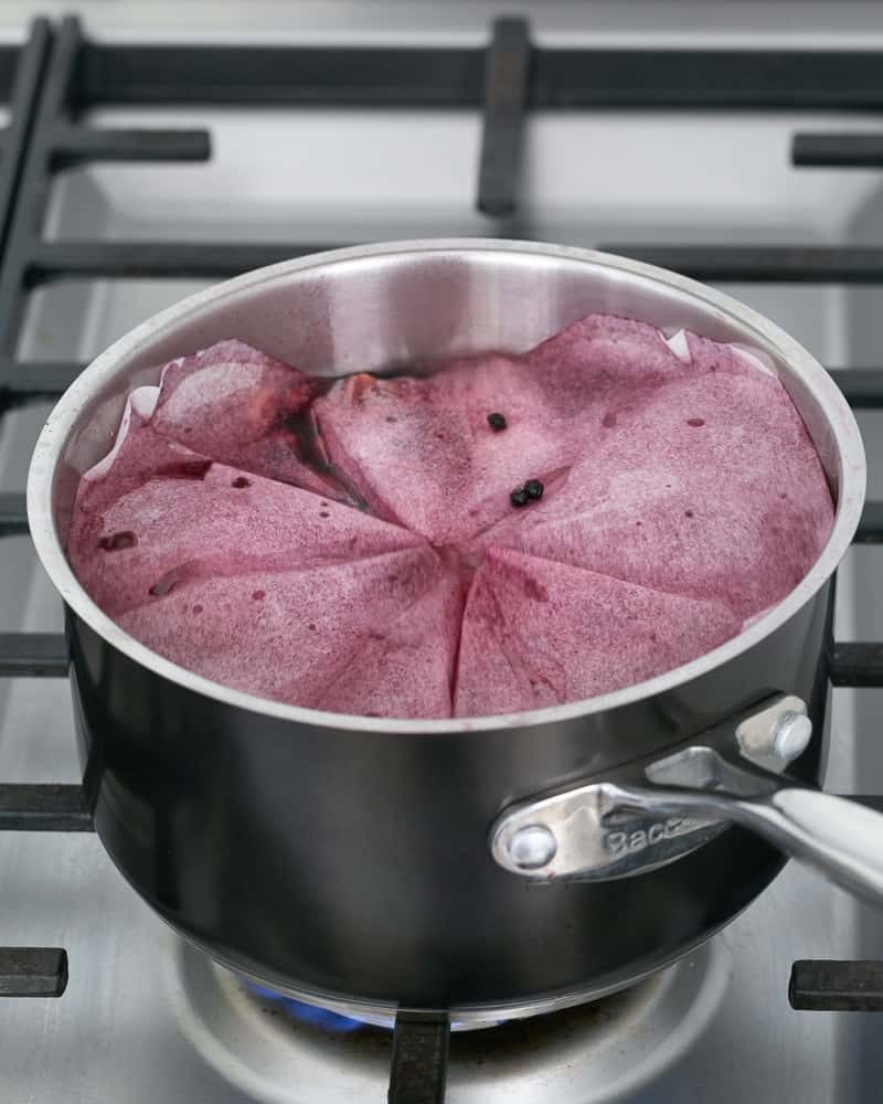 Cartouche over a pot with pears poaching in wine