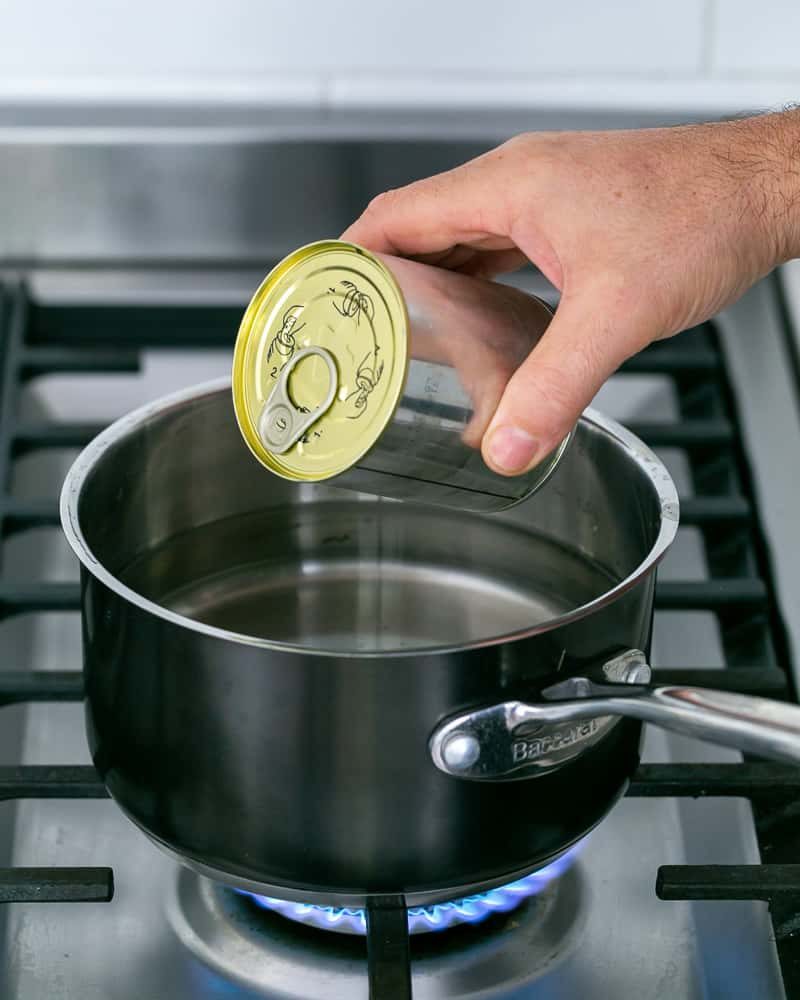 Immersing can of condensed milk in boiling water